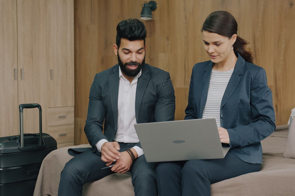 Two colleagues going through work on a laptop