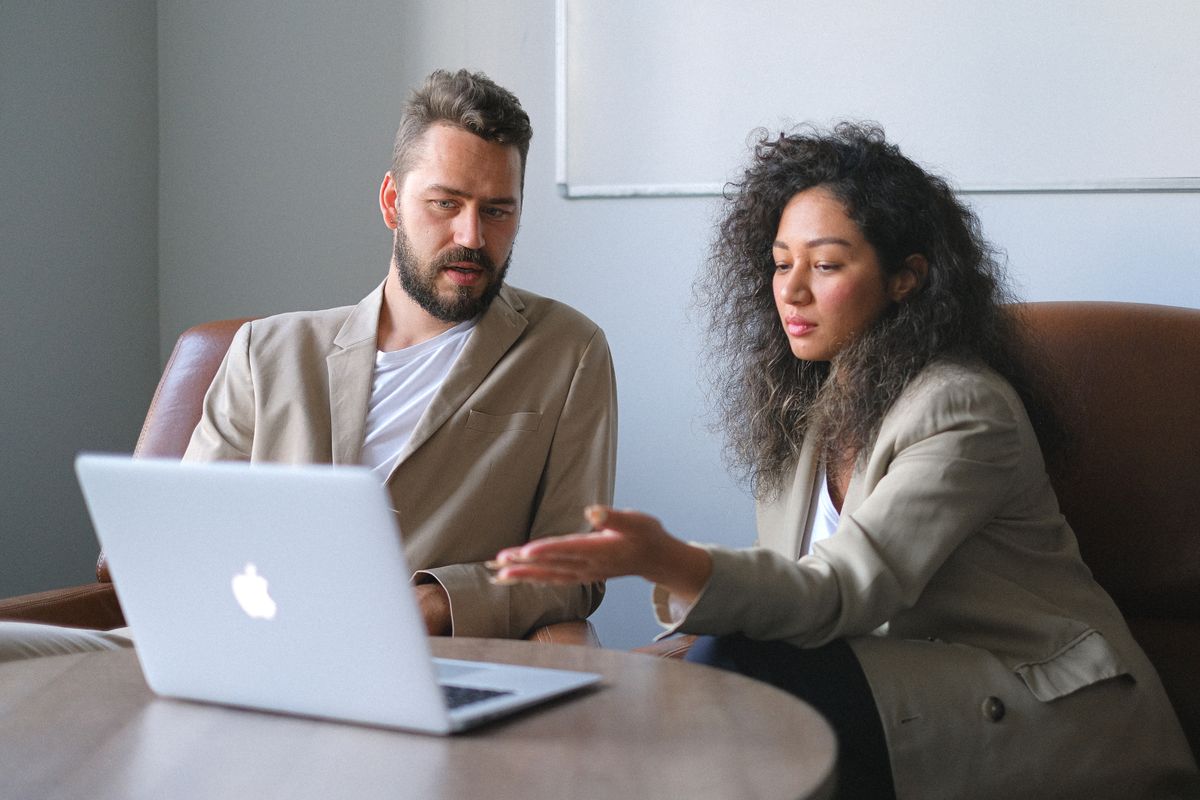 Two colleagues going through work on a laptop